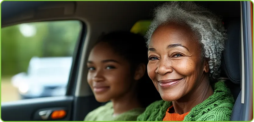 two women sit in a car and smile