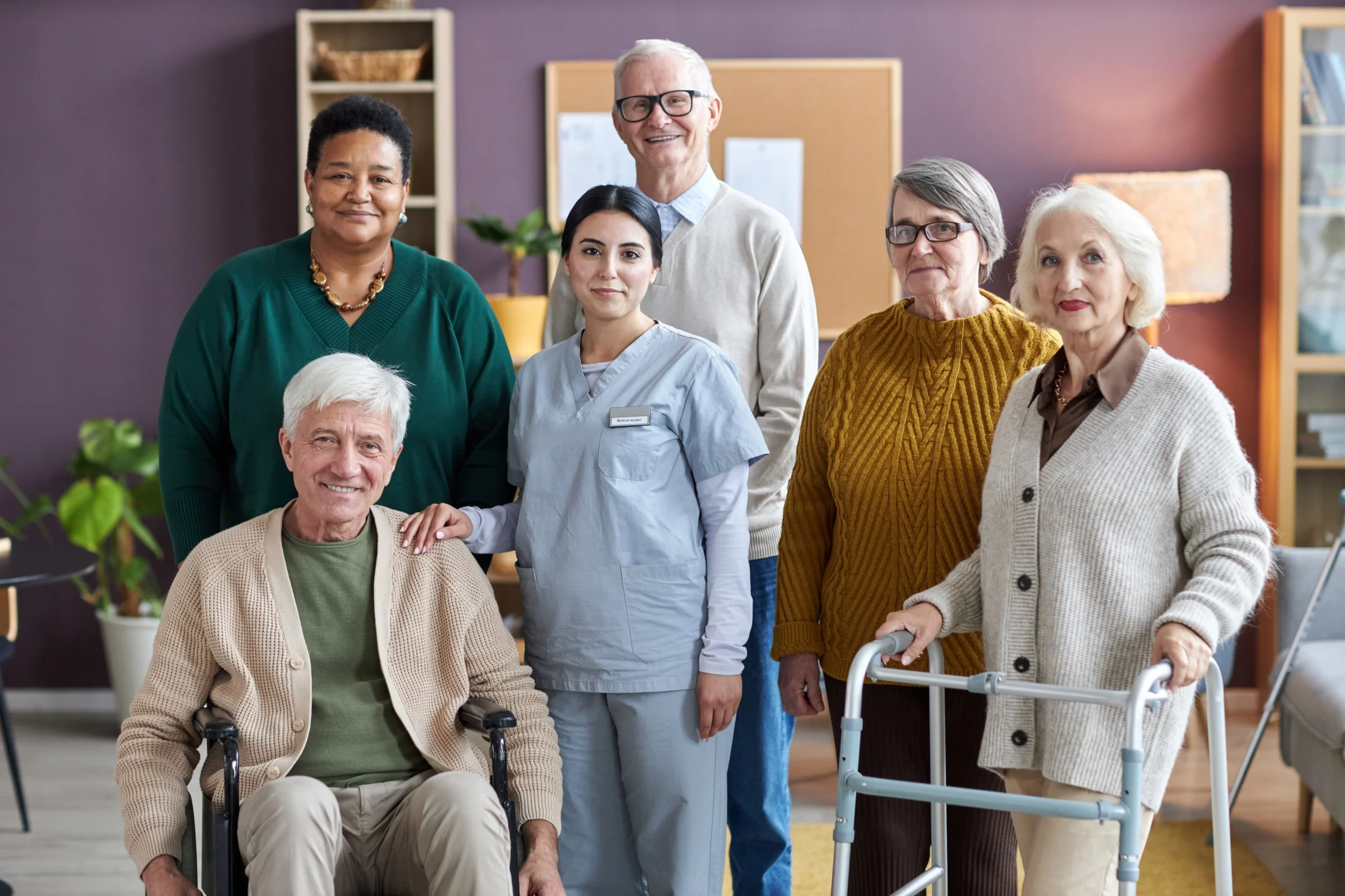 Group of seniors and caregivers smiling together in a senior care facility in Philadelphia